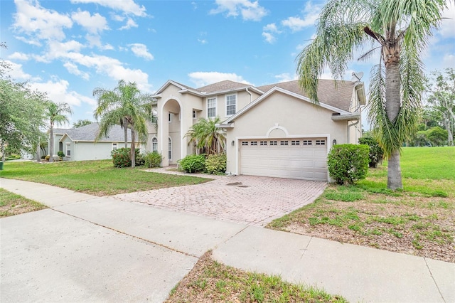 239 Beacon Pointe Dr, Ocoee, FL 34761 - view of front of house with an attached garage, driveway, stucco siding, and a front lawn