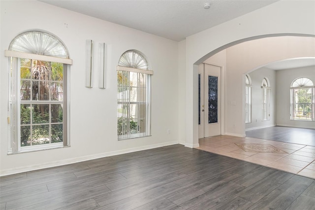 239 Beacon Pointe Dr, Ocoee, FL 34761 - spare room with wood finished floors, arched walkways, and baseboards