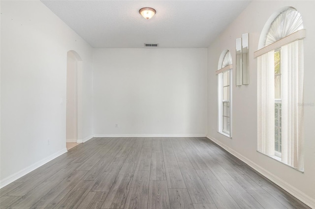 239 Beacon Pointe Dr, Ocoee, FL 34761 - unfurnished room featuring wood finished floors, arched walkways, and baseboards