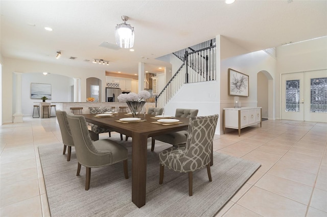 239 Beacon Pointe Dr, Ocoee, FL 34761 - dining space with arched walkways, light tile patterned floors, stairs, recessed lighting, and baseboards