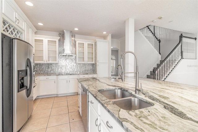 239 Beacon Pointe Dr, Ocoee, FL 34761 - kitchen featuring appliances with stainless steel finishes, wall chimney range hood, a sink, white cabinetry, and recessed lighting