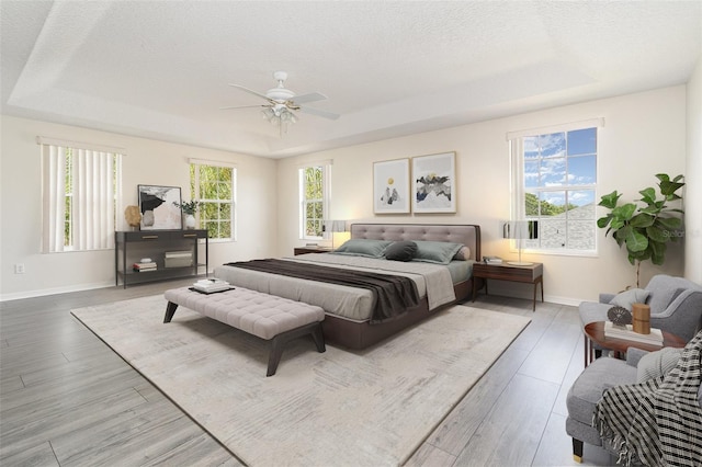 239 Beacon Pointe Dr, Ocoee, FL 34761 - bedroom with a raised ceiling, baseboards, wood finished floors, a textured ceiling, and a ceiling fan