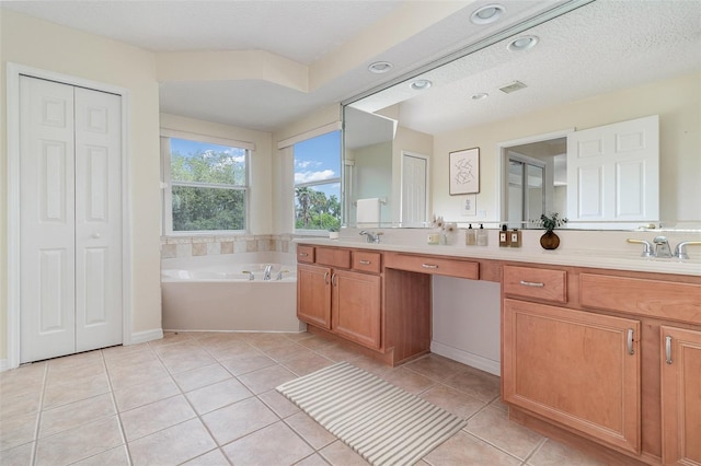 239 Beacon Pointe Dr, Ocoee, FL 34761 - full bath with a closet, double vanity, a garden tub, tile patterned flooring, and a textured ceiling