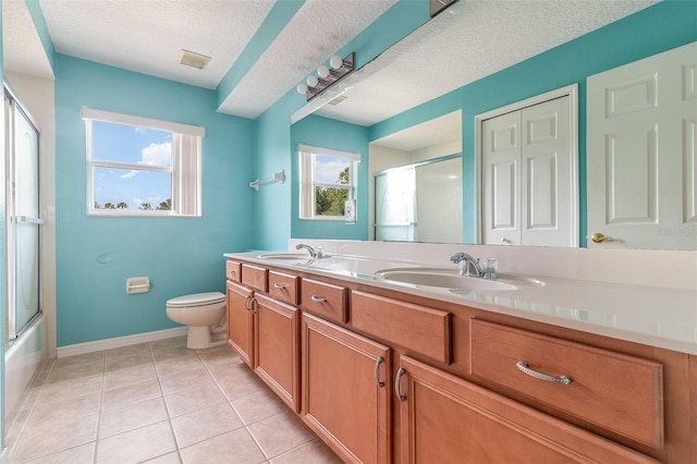 239 Beacon Pointe Dr, Ocoee, FL 34761 - full bathroom featuring double vanity, a textured ceiling, toilet, tile patterned flooring, and baseboards