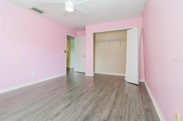 239 Beacon Pointe Dr, Ocoee, FL 34761 - unfurnished bedroom featuring wood finished floors, a closet, baseboards, a textured ceiling, and ceiling fan