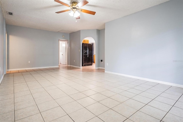 7347 Pulsar St, New Port Richey, FL 34652 - unfurnished room featuring a ceiling fan, a textured ceiling, arched walkways, baseboards, and light tile patterned floors