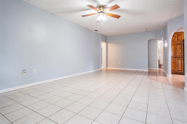 7347 Pulsar St, New Port Richey, FL 34652 - spare room featuring arched walkways, a textured ceiling, ceiling fan, light tile patterned floors, and baseboards