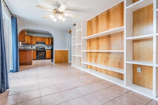 7347 Pulsar St, New Port Richey, FL 34652 - kitchen featuring black / electric stove, range hood, brown cabinets, arched walkways, and a ceiling fan