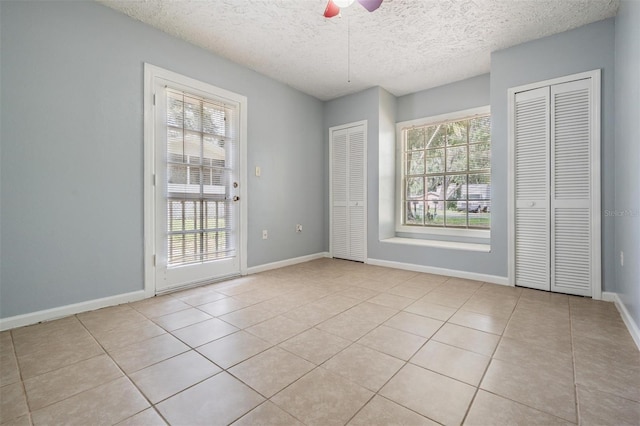 7347 Pulsar St, New Port Richey, FL 34652 - empty room featuring light tile patterned floors, a ceiling fan, a textured ceiling, and baseboards