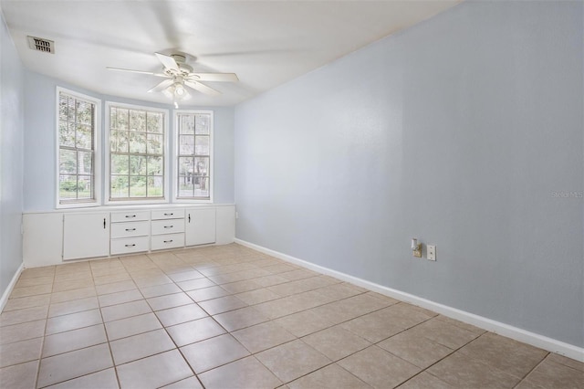 7347 Pulsar St, New Port Richey, FL 34652 - empty room featuring light tile patterned floors, a ceiling fan, and baseboards