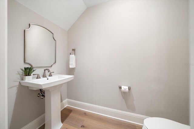 12 Country Club Ln, Belleair, FL 33756 - bathroom featuring wood finished floors, baseboards, toilet, and vaulted ceiling