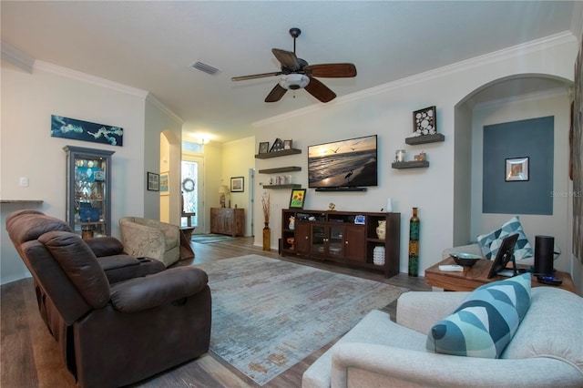 2121 Worthington Greens Dr, Sun City Center, FL 33573 - living room featuring arched walkways, ornamental molding, ceiling fan, and wood finished floors
