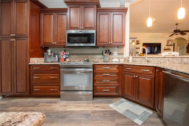 2121 Worthington Greens Dr, Sun City Center, FL 33573 - kitchen with stainless steel appliances, crown molding, a ceiling fan, a sink, and light wood-style flooring