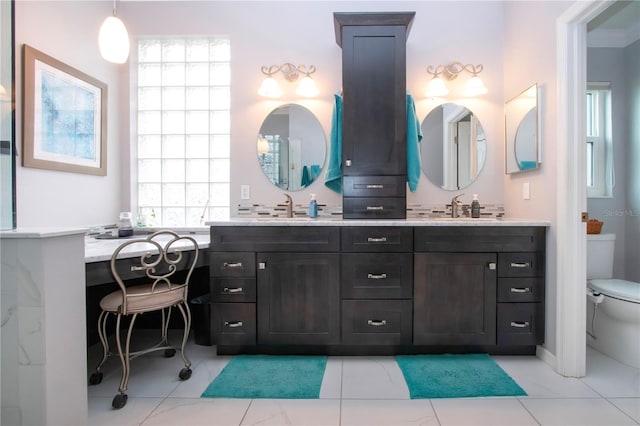 2121 Worthington Greens Dr, Sun City Center, FL 33573 - bathroom featuring toilet, double vanity, and plenty of natural light