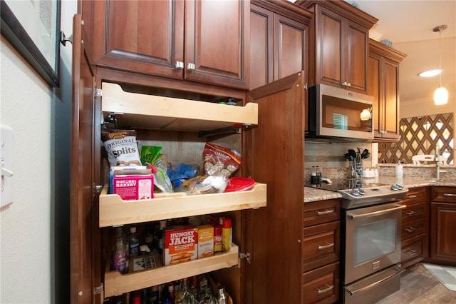 2121 Worthington Greens Dr, Sun City Center, FL 33573 - kitchen featuring appliances with stainless steel finishes, decorative backsplash, light stone countertops, and pendant lighting