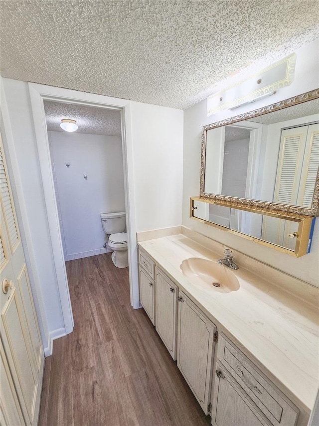 6020 Shore Blvd S Unit 1008, Gulfport, FL 33707 - bathroom with toilet, a textured ceiling, wood finished floors, and vanity