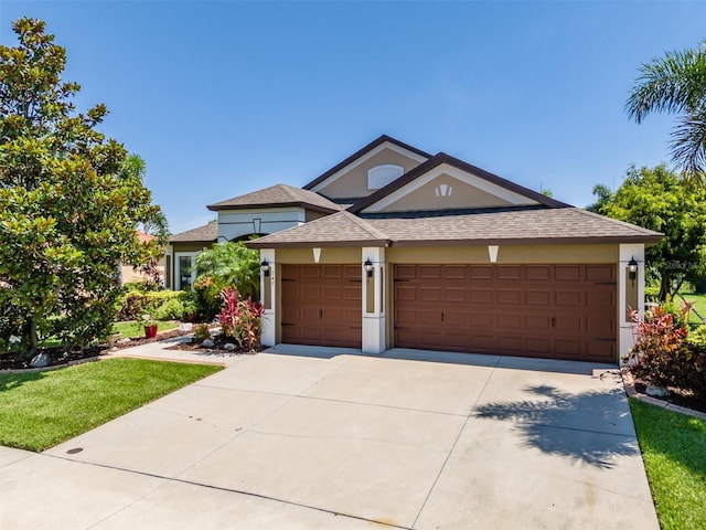 347 Cockle Shell Loop, Apollo Beach, FL 33572 - view of front facade with stucco siding, roof with shingles, an attached garage, and driveway