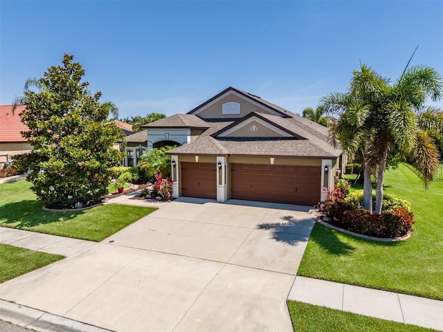 347 Cockle Shell Loop, Apollo Beach, FL 33572 - view of front of house featuring a front lawn, an attached garage, a shingled roof, and stucco siding