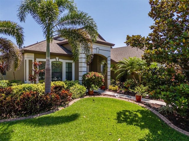 347 Cockle Shell Loop, Apollo Beach, FL 33572 - view of front of house with a front yard, stucco siding, and roof with shingles