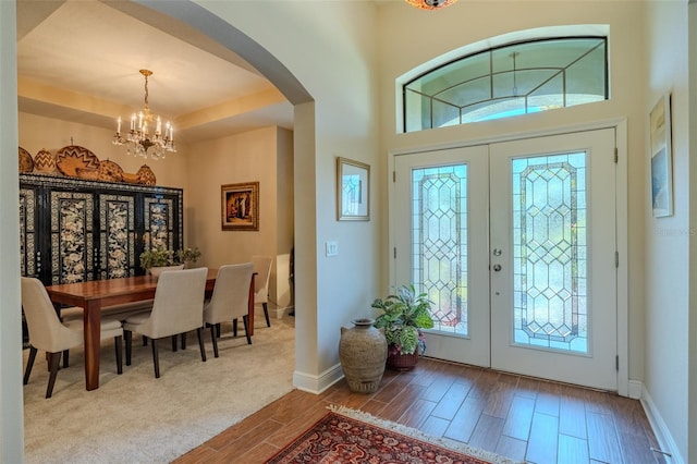 347 Cockle Shell Loop, Apollo Beach, FL 33572 - foyer entrance with a chandelier, arched walkways, wood finished floors, baseboards, and french doors