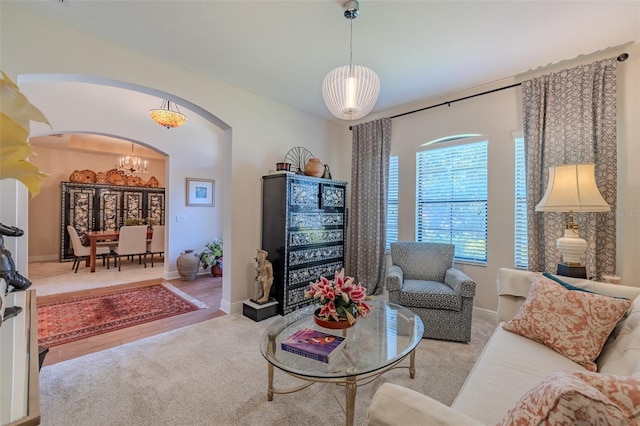 347 Cockle Shell Loop, Apollo Beach, FL 33572 - living area featuring arched walkways, a chandelier, carpet floors, and baseboards