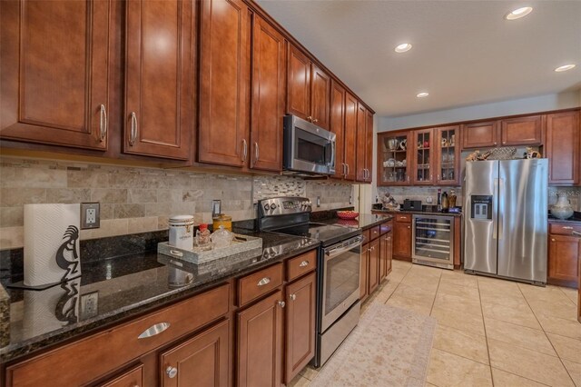 347 Cockle Shell Loop, Apollo Beach, FL 33572 - kitchen featuring stainless steel appliances, wine cooler, decorative backsplash, dark stone countertops, and glass insert cabinets