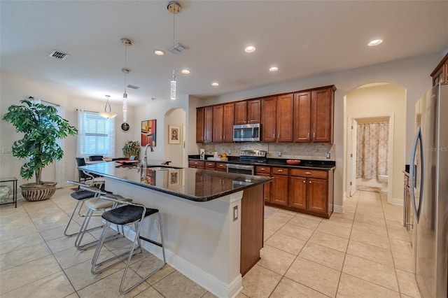 347 Cockle Shell Loop, Apollo Beach, FL 33572 - kitchen featuring appliances with stainless steel finishes, arched walkways, light tile patterned floors, a kitchen breakfast bar, and recessed lighting