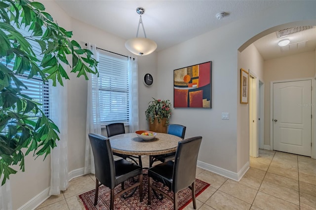 347 Cockle Shell Loop, Apollo Beach, FL 33572 - dining space with arched walkways, light tile patterned floors, and baseboards