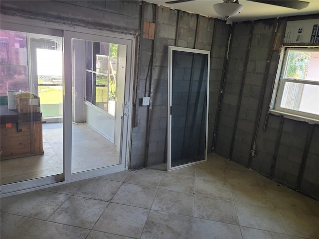 860 Bruce Ave, Clearwater Beach, FL 33767 - tiled empty room featuring concrete block wall, ceiling fan, and healthy amount of natural light
