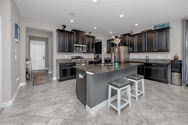 11320 Chilly Water Ct, Riverview, FL 33569 - kitchen featuring stainless steel appliances, a breakfast bar, baseboards, a kitchen island with sink, and recessed lighting