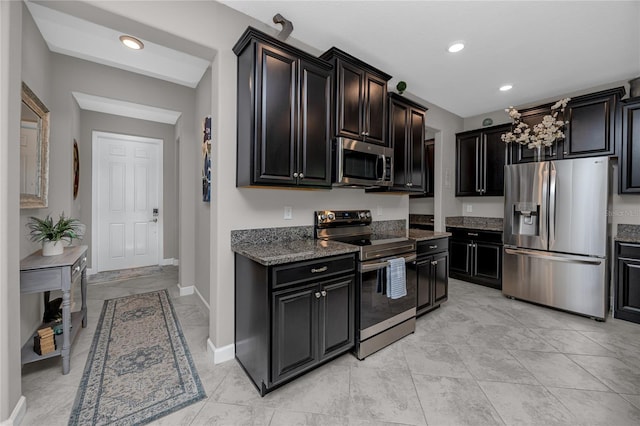 11320 Chilly Water Ct, Riverview, FL 33569 - kitchen featuring stainless steel appliances, dark stone counters, recessed lighting, dark cabinets, and baseboards