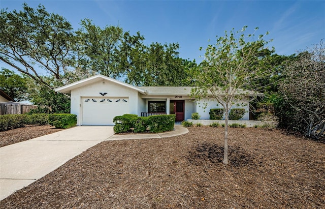 1648 Concord St, Dunedin, FL 34698 - single story home featuring a garage, stucco siding, driveway, and covered porch