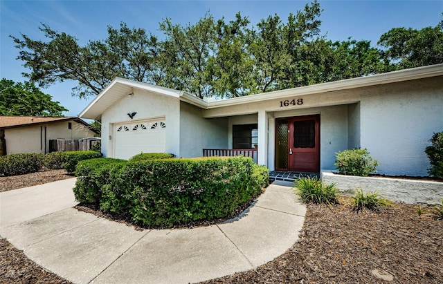 1648 Concord St, Dunedin, FL 34698 - view of front of property featuring a porch, stucco siding, and a garage