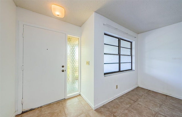 1648 Concord St, Dunedin, FL 34698 - entryway featuring light tile patterned floors, a textured ceiling, and baseboards
