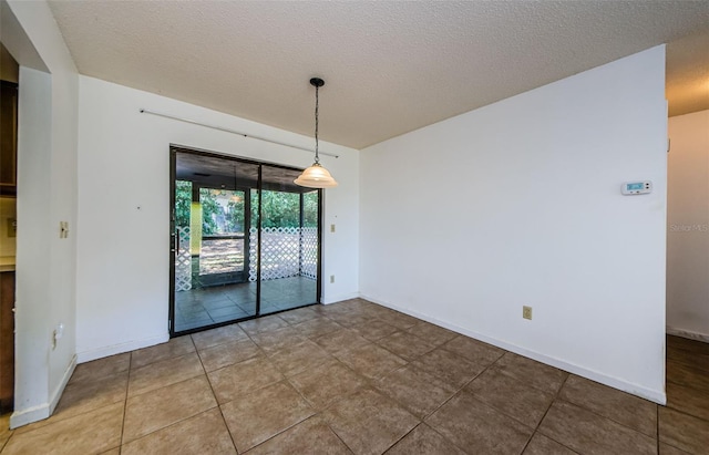 1648 Concord St, Dunedin, FL 34698 - empty room featuring a textured ceiling, light tile patterned floors, and baseboards