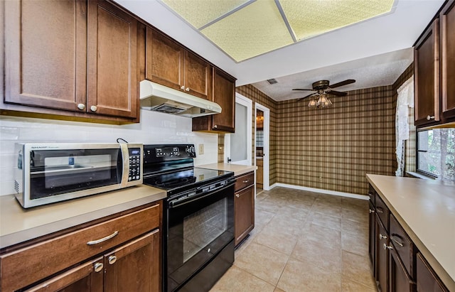 1648 Concord St, Dunedin, FL 34698 - kitchen featuring under cabinet range hood, black electric range, stainless steel microwave, light countertops, and ceiling fan