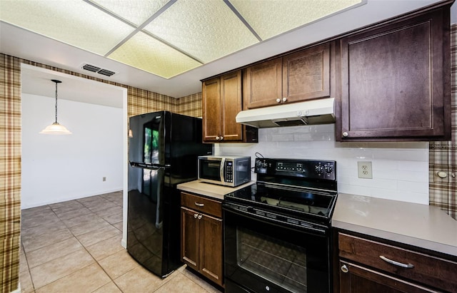 1648 Concord St, Dunedin, FL 34698 - kitchen with black appliances, under cabinet range hood, light countertops, dark brown cabinetry, and pendant lighting