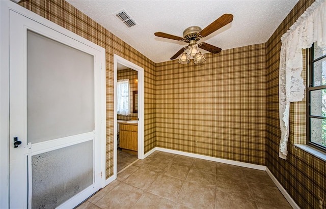1648 Concord St, Dunedin, FL 34698 - tiled spare room with wallpapered walls, baseboards, a textured ceiling, and a ceiling fan