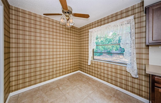1648 Concord St, Dunedin, FL 34698 - spare room with a textured ceiling, wallpapered walls, baseboards, and ceiling fan