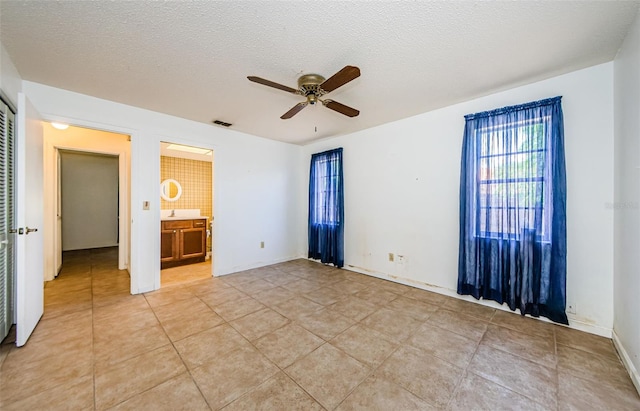 1648 Concord St, Dunedin, FL 34698 - empty room with ceiling fan, a textured ceiling, and light tile patterned floors