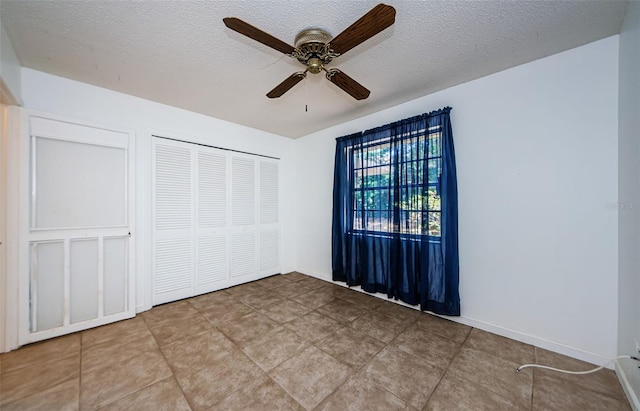 1648 Concord St, Dunedin, FL 34698 - unfurnished bedroom with a textured ceiling, a closet, tile patterned floors, and a ceiling fan