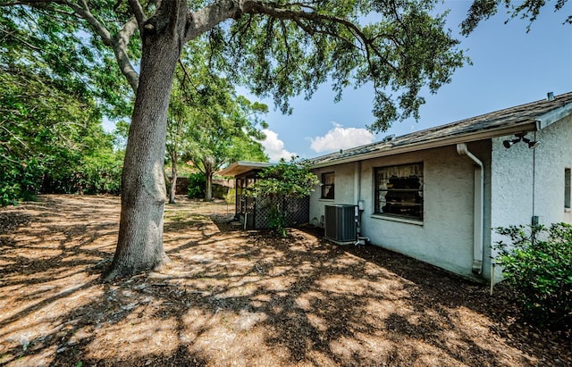 1648 Concord St, Dunedin, FL 34698 - view of side of home featuring central air condition unit and stucco siding