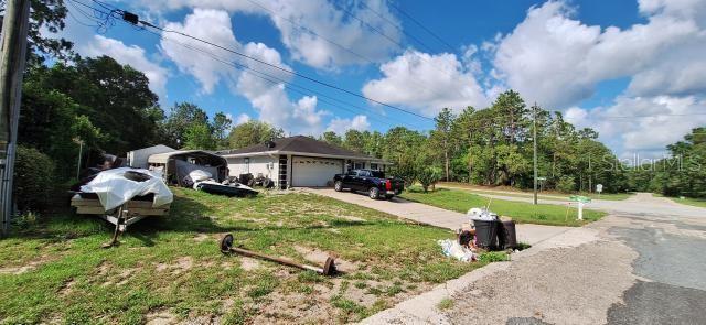 1160 W Geneva Pl, Citrus Springs, FL 34434 - single story home featuring an attached garage, a front lawn, and driveway