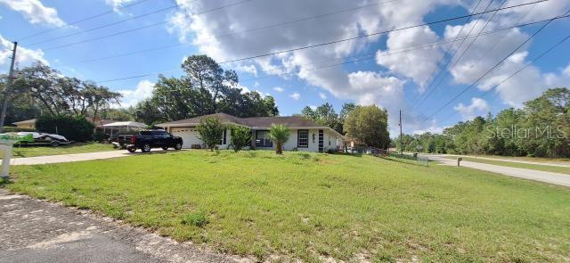 1160 W Geneva Pl, Citrus Springs, FL 34434 - single story home featuring driveway, an attached garage, and a front yard