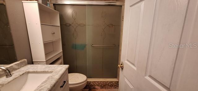 1160 W Geneva Pl, Citrus Springs, FL 34434 - bathroom featuring vanity, a stall shower, and toilet