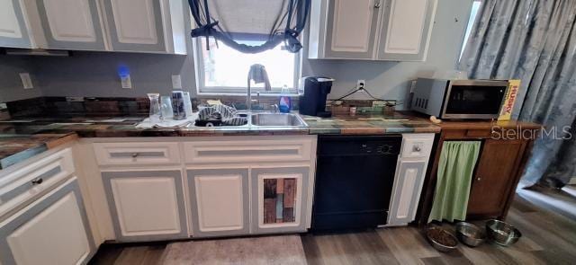 1160 W Geneva Pl, Citrus Springs, FL 34434 - kitchen featuring black dishwasher, stainless steel microwave, white cabinetry, a sink, and wood finished floors