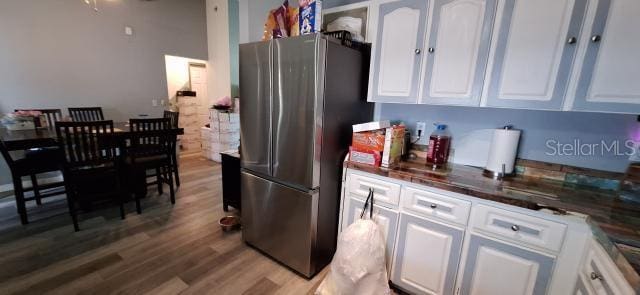 1160 W Geneva Pl, Citrus Springs, FL 34434 - kitchen with freestanding refrigerator, white cabinetry, wood finished floors, and dark countertops