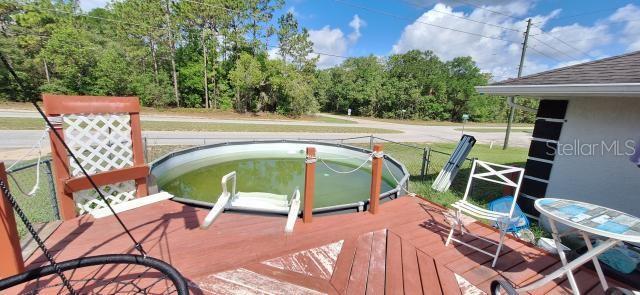 1160 W Geneva Pl, Citrus Springs, FL 34434 - wooden terrace featuring view of wooded area