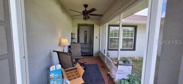 1160 W Geneva Pl, Citrus Springs, FL 34434 - property entrance with stucco siding, a ceiling fan, and a porch