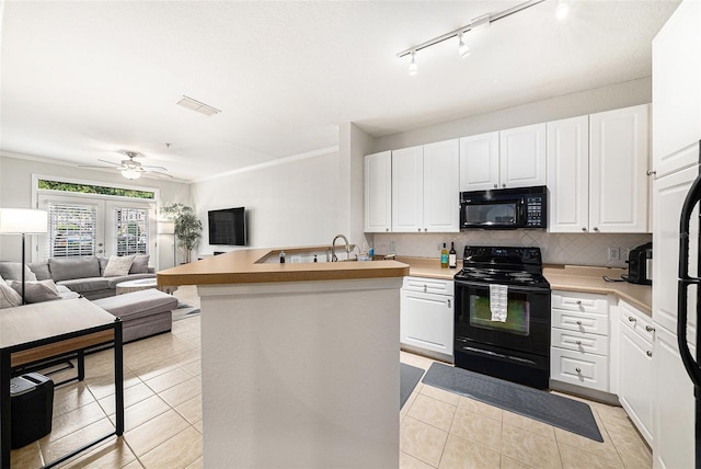 4221 W Spruce St Unit 2104, Tampa, FL 33607 - kitchen featuring black appliances, light tile patterned floors, open floor plan, decorative backsplash, and crown molding